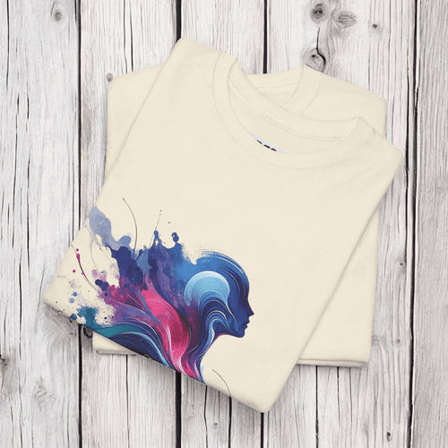 Folded Natural tee with striking multicolor abstract design on a wood surface