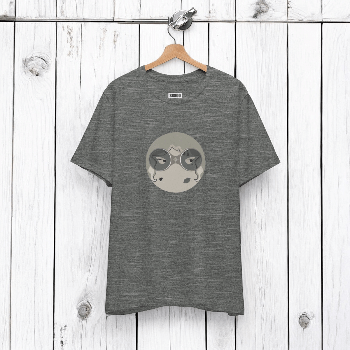 Gray tee with circular graphic of face with closed eyes in gray shades, "SAROO" brand on white wood panel