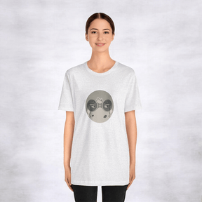 Person in light gray tee with circular design of stylized eyes and abstract shapes on gray backdrop