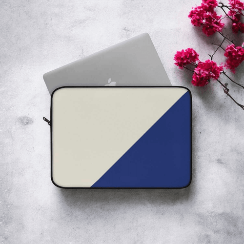 Laptop with teel and beige protective case placed on white marble surface next to pink flowers in soft daylight