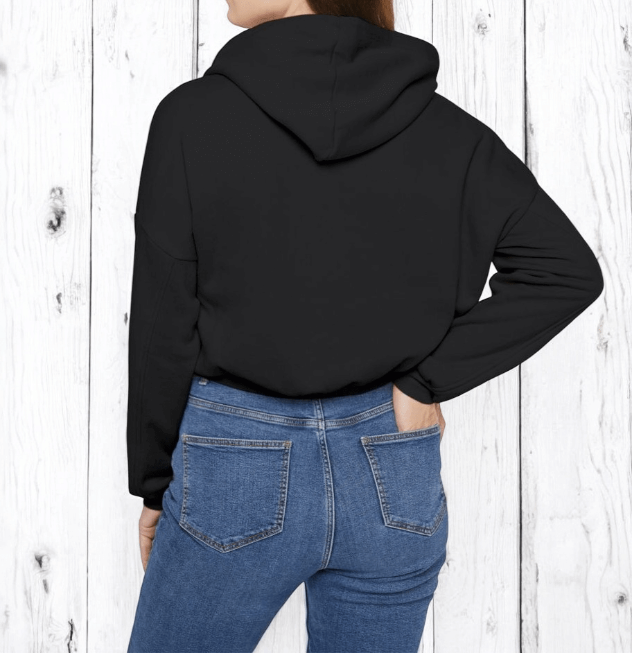 Person with hands in back pockets wearing black cotton hoodie featuring white geometric design on the back