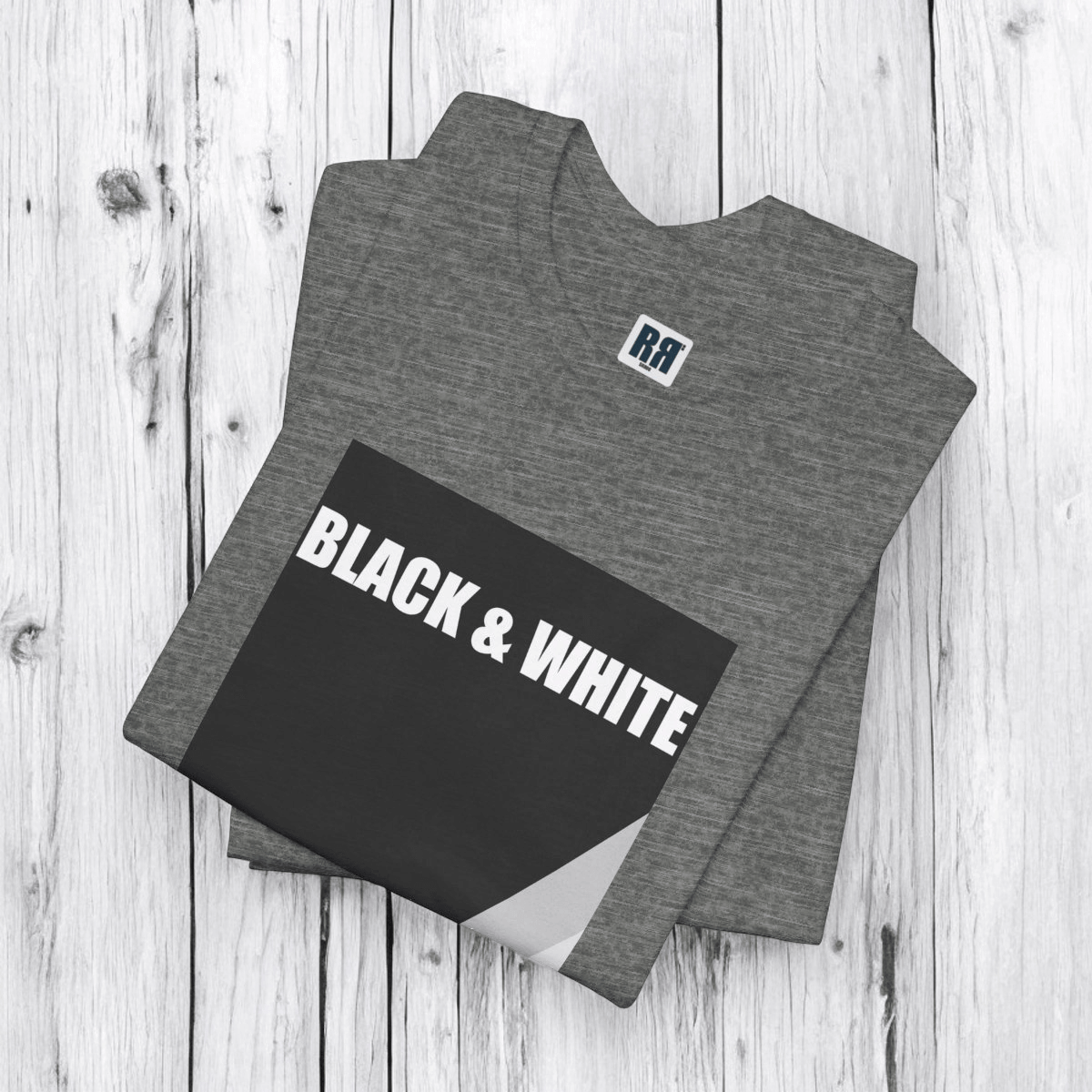 Deep heather gray t-shirt with black and white rock graphic laid flat on white wood texture surface