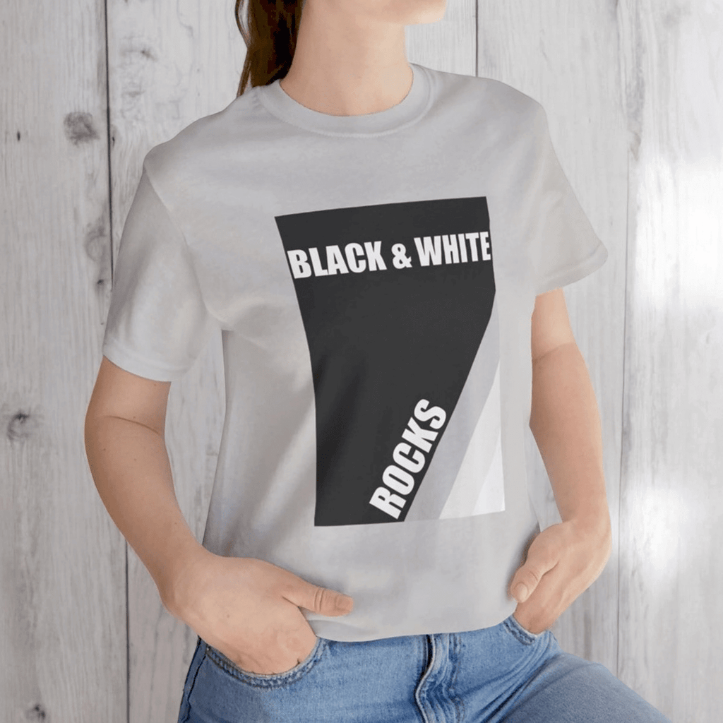 Person in silver t-shirt with black and white rock print reading 'BLACK & WHITE ROCKS' and jeans
