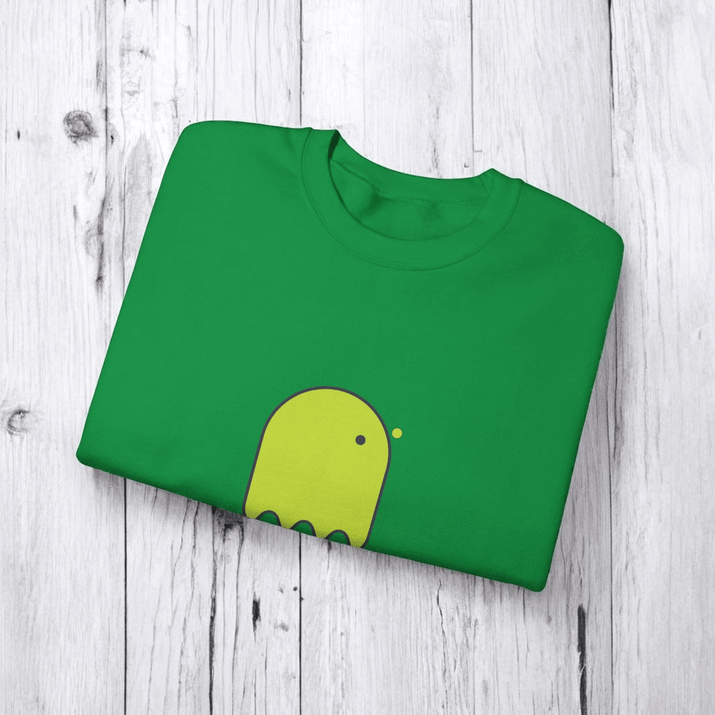 Green cotton T-shirt featuring a yellow cartoon graphic, neatly folded on a wooden surface with visible short sleeves