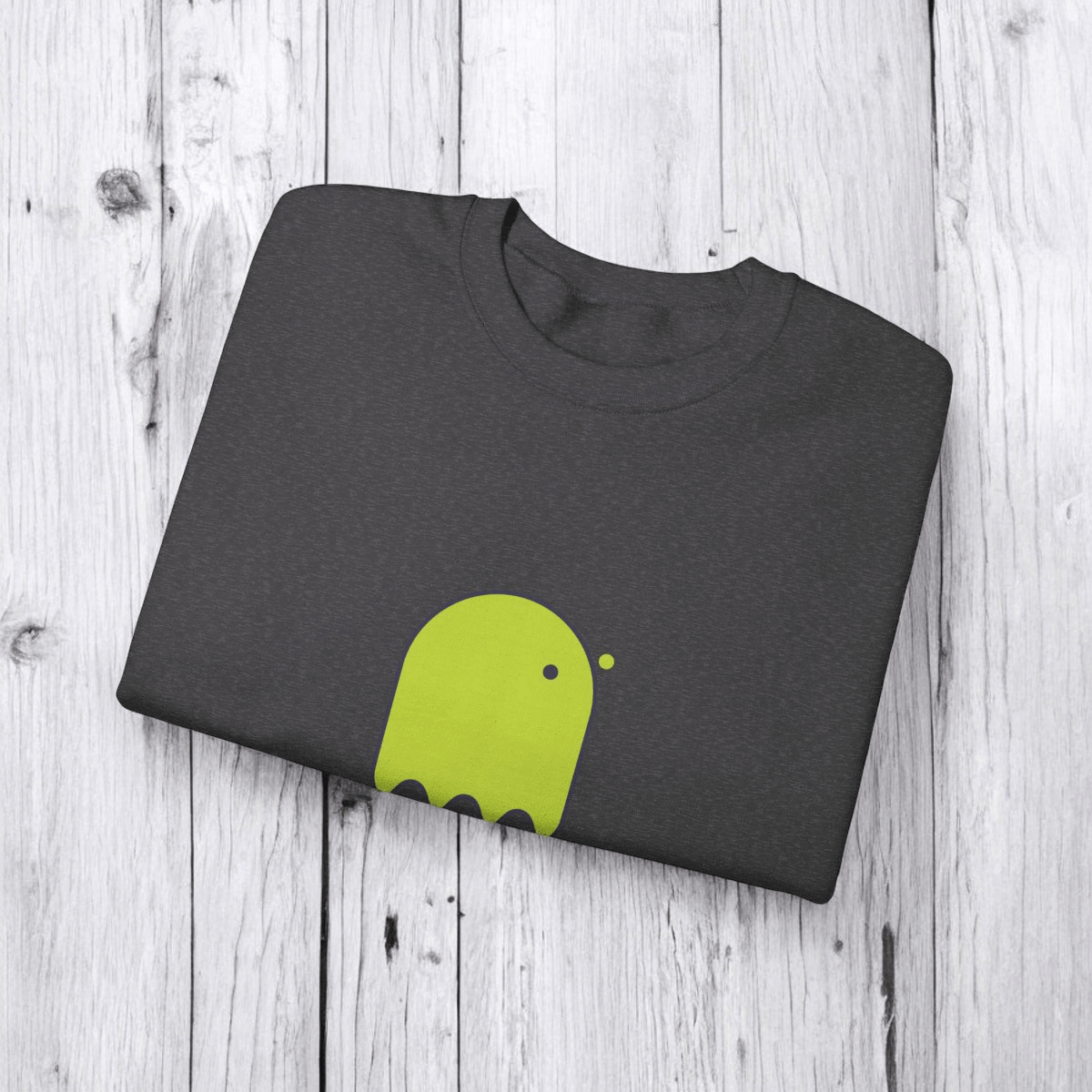 Folded gray cotton t-shirt with lime green abstract graphic, neatly folded on a light wooden surface