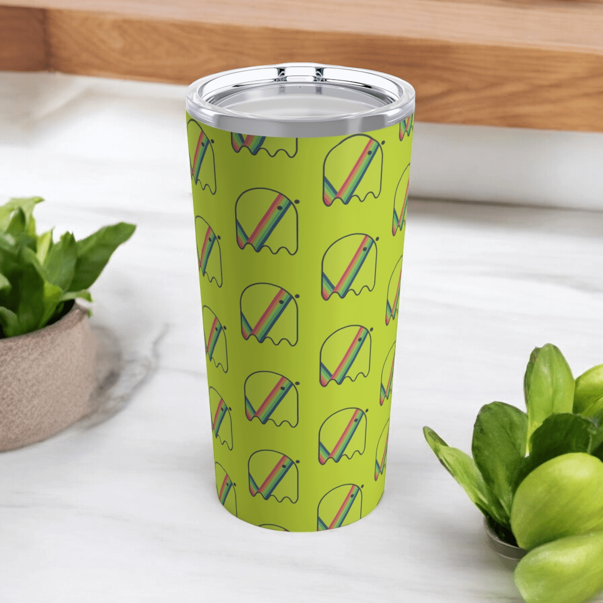 Green insulated tumbler with stainless steel rim, colorful abstract pattern and matte finish on marble surface