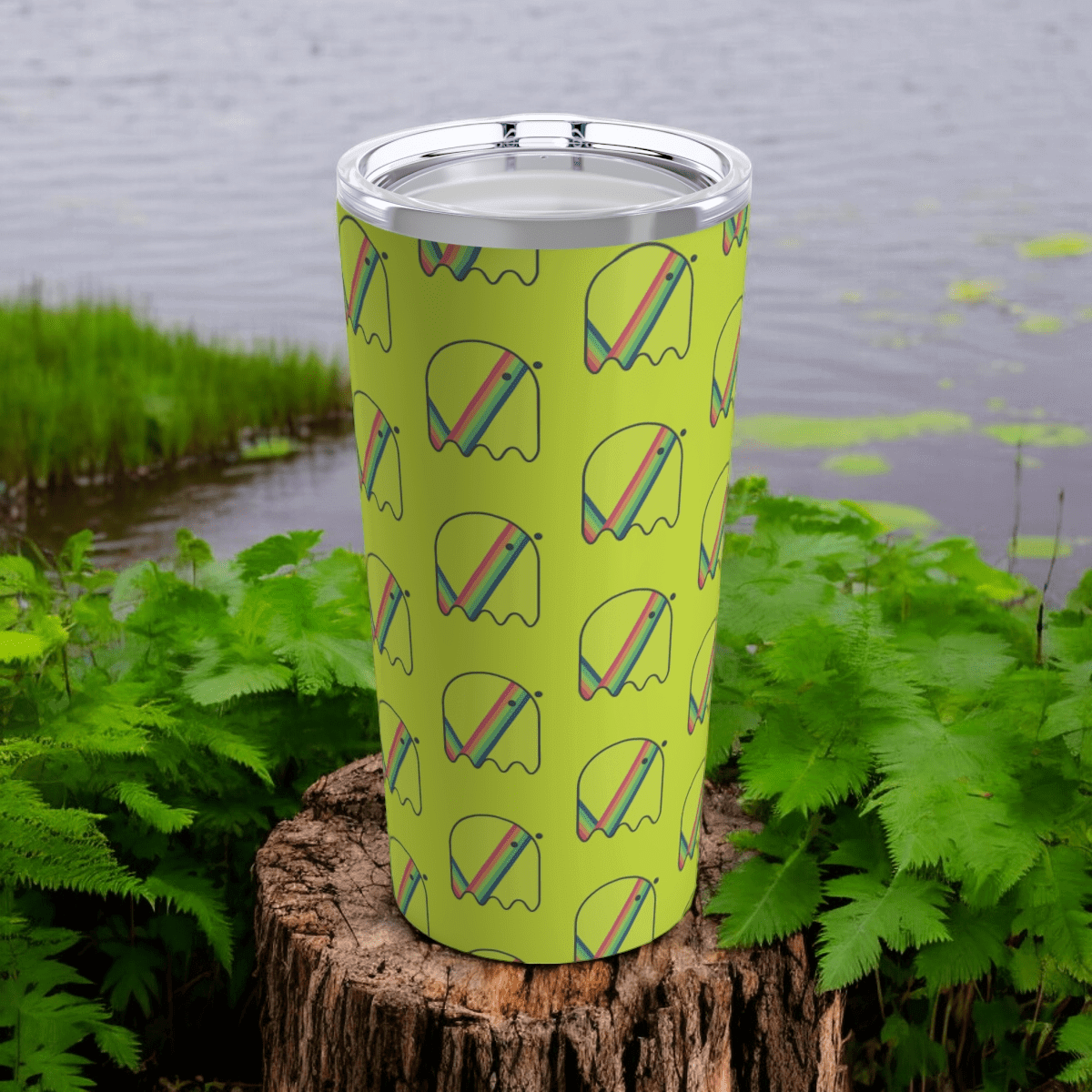 20oz stainless steel tumbler with colorful ghost pattern, matte finish, and clear lid placed outdoors on a tree stump