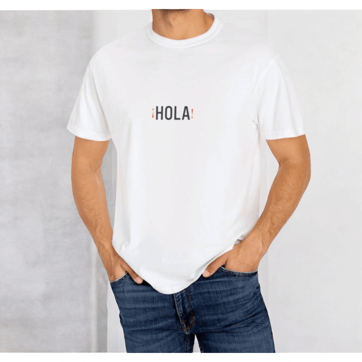 White cotton T-shirt with short sleeves featuring bold blue Hola Hello text design in a relaxed fit style
