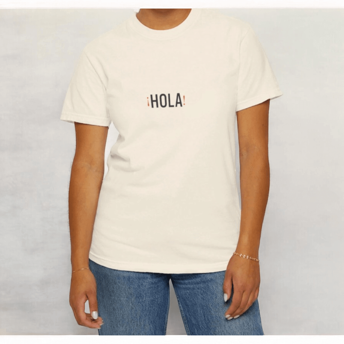 Ivory cotton short-sleeve t-shirt with crew neckline featuring bold red Hola Hello Spanish text on front