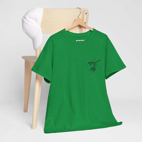 Green cotton T-shirt with bird graphic draped over a wooden chair next to a white baseball cap in casual setting