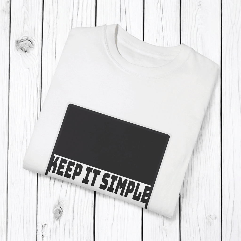 White cotton T-shirt with minimalist black text design reading 'KEEP IT SIMPLE' displayed on a wooden surface