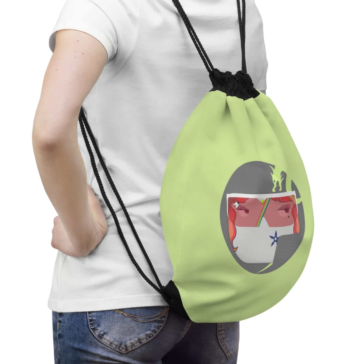 Green drawstring backpack made of canvas featuring a stylized face illustration, worn over the shoulders with jeans